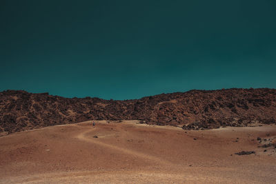 Scenic view of desert against clear blue sky