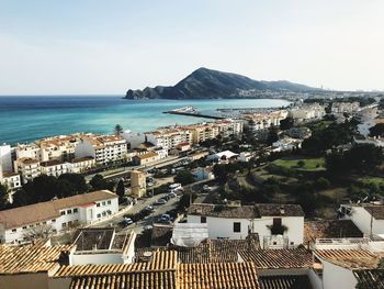 High angle view of city by sea against sky