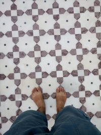 Low section of man standing on patterned floor