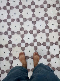 Low section of man standing on patterned floor
