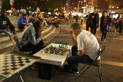 Group of people sitting on table in city