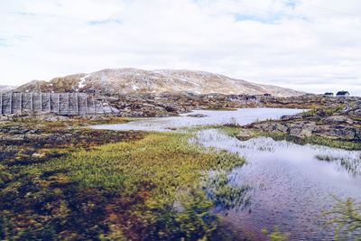 Scenic view of river against cloudy sky