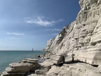 Rock formations by sea against sky