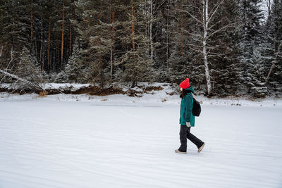 Full length of woman skiing on snow covered field