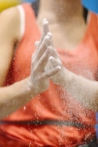 Midsection of woman with hands clasped by sand