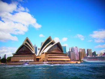 View of buildings in sea against cloudy sky