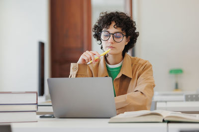 Young woman using laptop at table