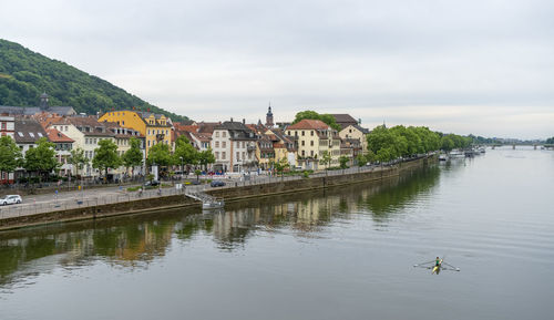 Scenic view of lake by buildings against sky