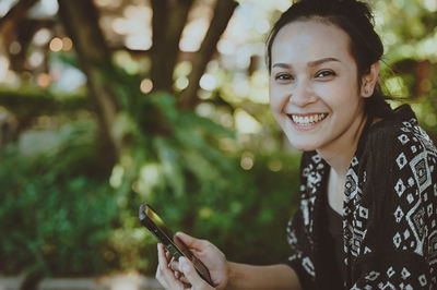 Young women with beautiful smile and hand holdind a mobile phone