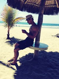 Full length of man holding umbrella at beach