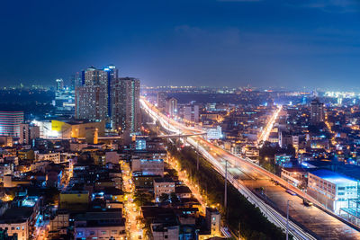 High angle view of illuminated buildings against sky at night