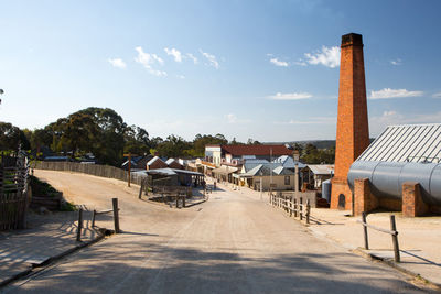 Houses by buildings against sky