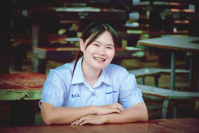 Portrait of smiling girl sitting on table