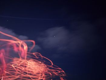 Low angle view of illuminated lights against sky at night