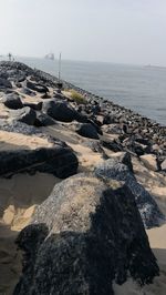 Rocks on beach against sky