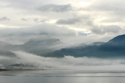 Scenic view of sea and mountains against sky