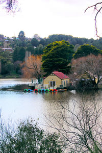 Scenic view of river by buildings against sky