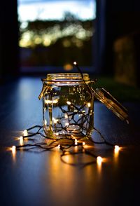 Close-up of illuminated lamp on table