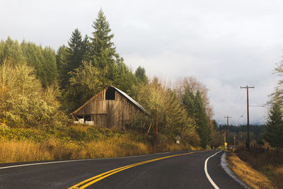 Road by trees against sky