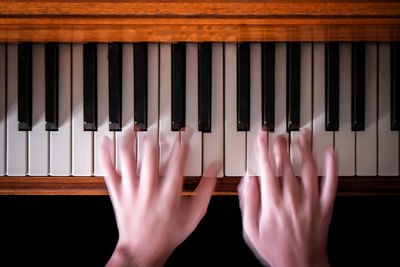 Close-up of hands playing piano