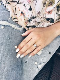 Midsection of woman with painted nails sitting outdoors