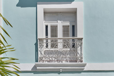 White window with small french  balcony in blue building of neoclassical style in cienfuegos, cuba. 