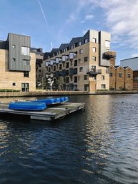 Boats moored on river against buildings in city