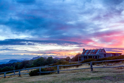 Built structure on field against sky at sunset