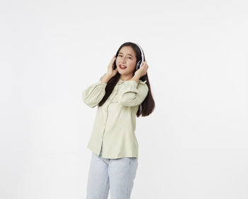 Portrait of a smiling young woman against white background