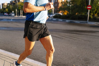 Unrecognizable senior retired man running through the city