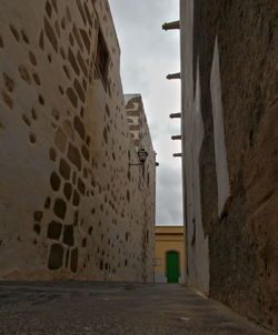 Alley amidst buildings against sky