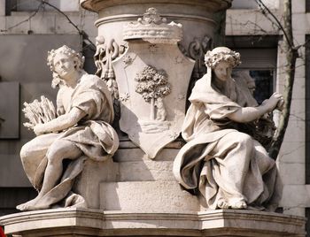 Two statues of woman with the shield of madrid in the center