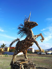 Statue on field against sky