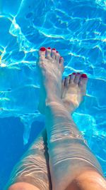 Low section of woman relaxing in swimming pool