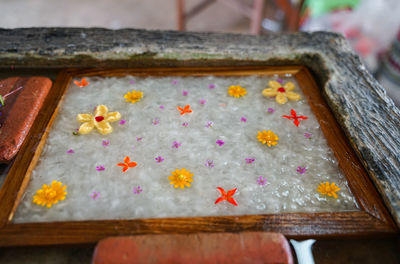 High angle view of pink petals on wooden table