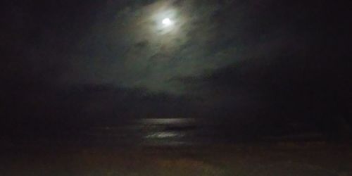 Low angle view of illuminated moon against sky at night