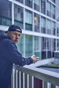 Young man standing at railing