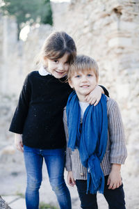 Portrait of happy siblings standing outdoors