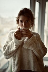 Portrait of young woman drinking coffee