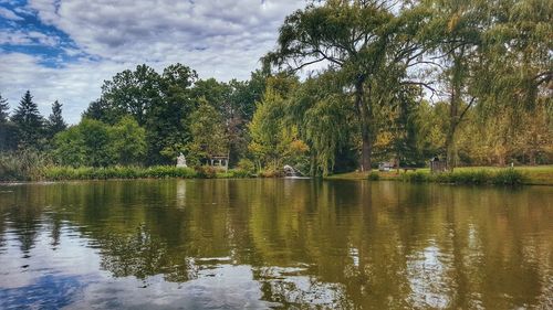 Scenic view of lake by trees in forest against sky