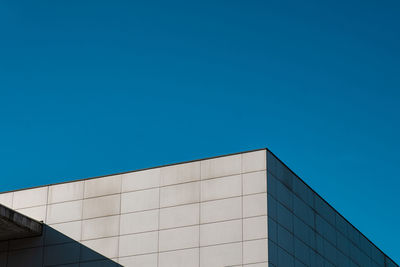 Low angle view of modern building against clear blue sky