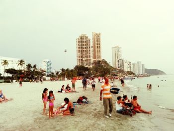 People on beach against built structures