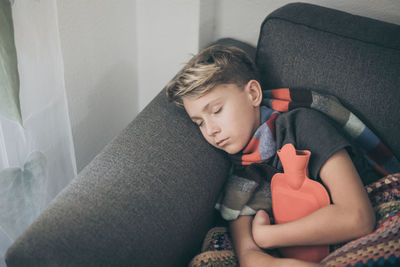 Boy sitting on sofa at home