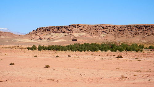 Scenic view of arid landscape against clear blue sky