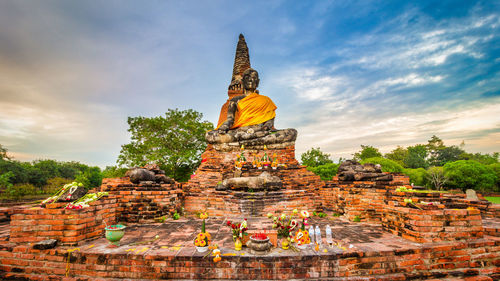 Statue of temple against cloudy sky