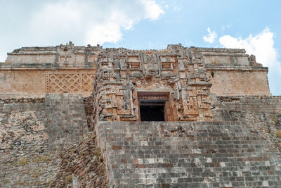 Low angle view of old building against cloudy sky