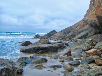 Rocks on beach against sky