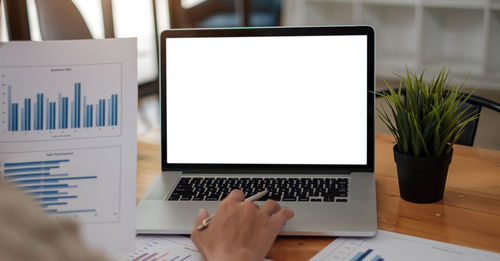 Low section of person using laptop on table