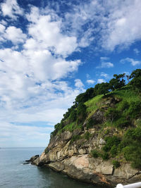 Scenic view of rocks by sea against sky