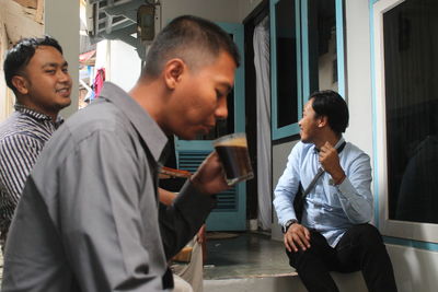 Side view of young man sitting at table
